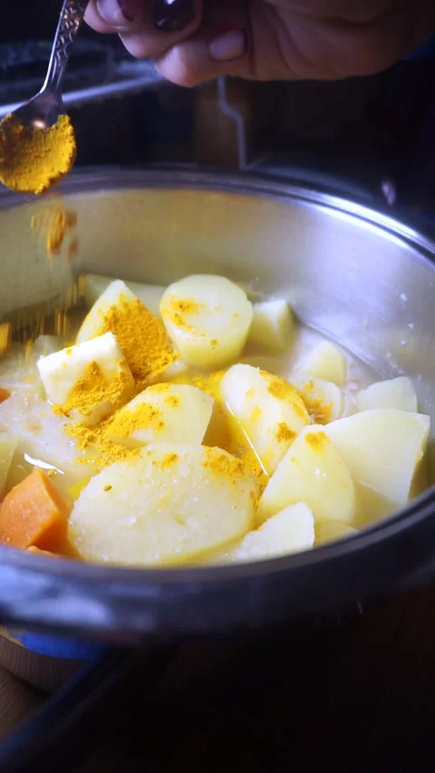 Spicing a pot of vegetables with curry in a dessert spoon. Indian and homemad Stock Footage 152648077
