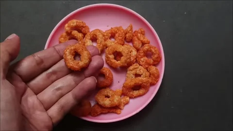 Spicy Crispy Ring Chips on a Pink Plate Stock Footage 324769811