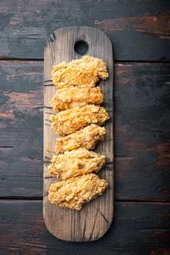 Spicy deep fried breaded chicken wings on dark wooden background, top view Stock Photos