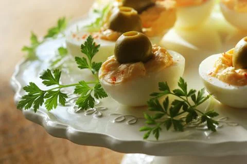Spicy deviled eggs garnished with green olives Stock Photos