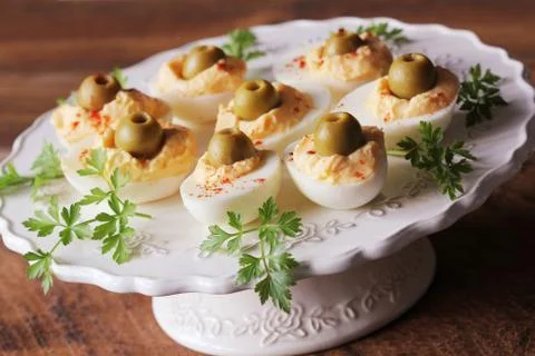 Spicy deviled eggs garnished with green olives Stock Photos