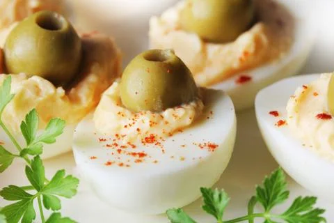 Spicy deviled eggs garnished with green olives Stock Photos