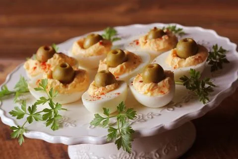 Spicy deviled eggs garnished with green olives Foto stock