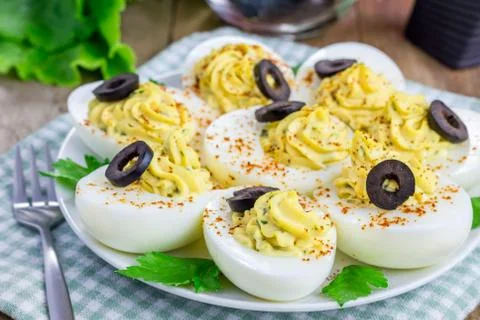 Spicy deviled eggs garnished with olives Foto stock