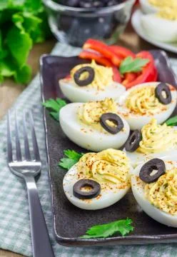 Spicy deviled eggs garnished with olives Foto stock