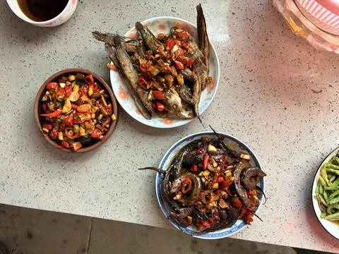 Spicy Fried Fish and Eel Dishes with Colorful Chili Garnish 스톡 사진