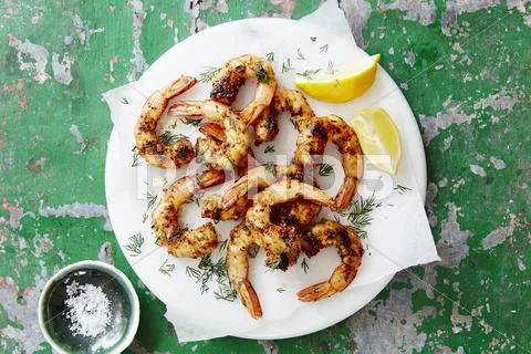 Spicy king prawns with lemon and dill Stock Photos