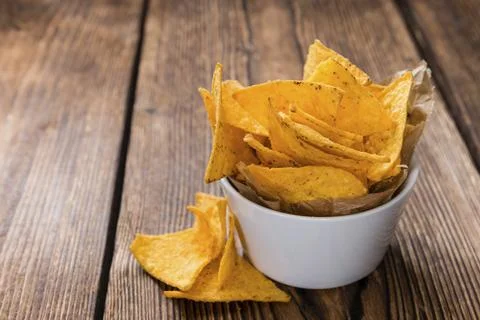 Spicy Nachos (close-up shot) on rustic wooden background Stock Photos