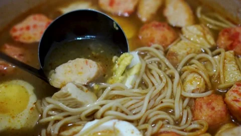 Spicy Noodle Soup with Boiled Eggs and Fish Balls Stock Footage 329955949
