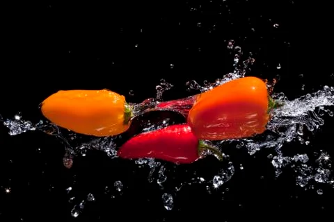 Spicy Peppers being splashed with water. Stock Photos