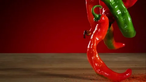 Spicy peppers fall into a cloud of ground red pepper seasoning powder Video stock 326627939