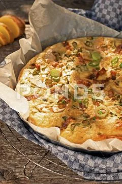 Spicy potato cake with apple wedges, onions and bacon Stock Photos