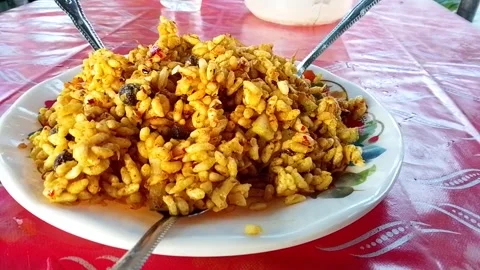 Spicy puffed rice dish served on plate with spoons over table. 스톡 동영상 346617452