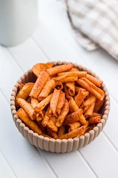 Spicy Rolled Corn Chips in Ceramic Bowl Close-Up Crispy Snack for Parties. Stock Photos