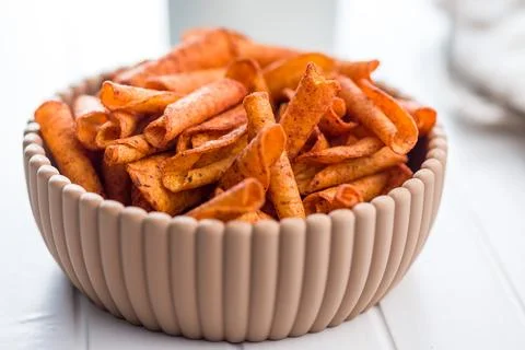 Spicy Rolled Corn Chips in Ceramic Bowl Close-Up Crispy Snack for Parties. Stock Photos