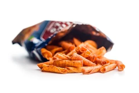 Spicy Rolled Corn Snacks Piled in an Open Bag on White Background. Stock Photos