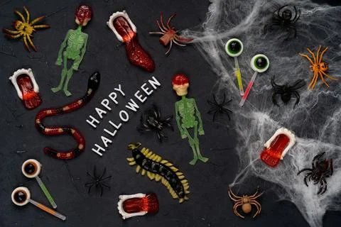 Spider web, snakes, insects made of candy and marmalade on a black background Stock Photos