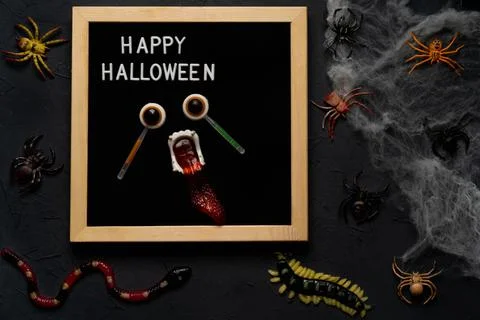 Spider web, snakes, insects made of candy and marmalade on a black background Foto stock