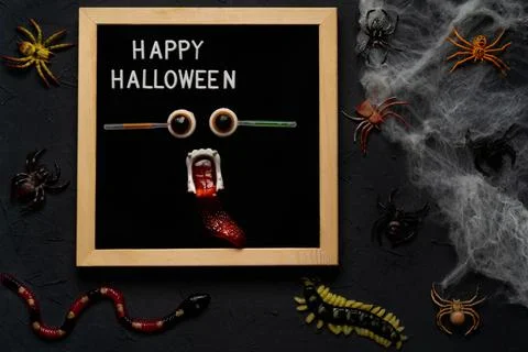 Spider web, snakes, insects made of candy and marmalade on a black background Stock Photos