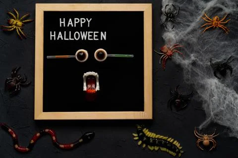 Spider web, snakes, insects made of candy and marmalade on a black background Foto stock