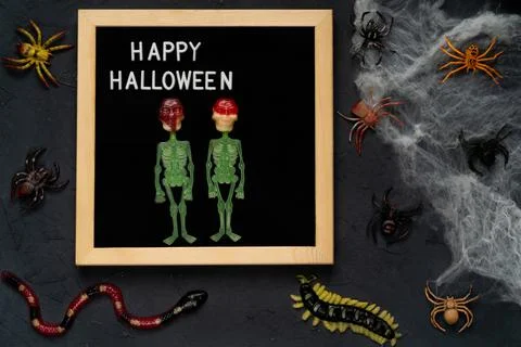 Spider web, snakes, insects made of candy and marmalade on a black background Foto stock
