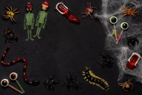 Spider web, snakes, insects made of candy and marmalade on a black background Foto stock