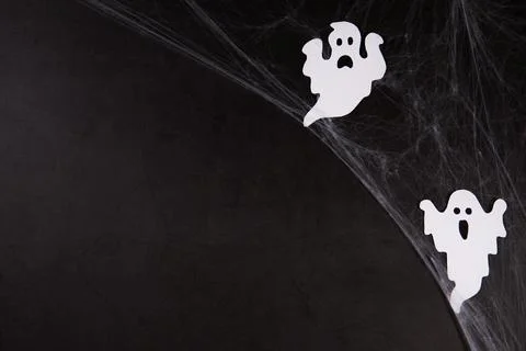 Spider web with white ghosts on black background Stock-Fotos