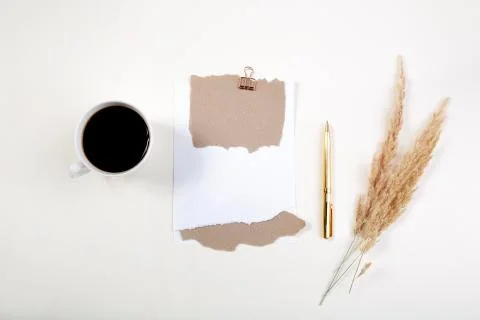 Spikelets and mockup of a white notepad with a cup of coffee on a light table Stock Photos