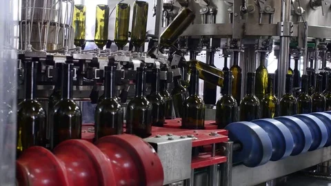 Spill of alcohol wine in glass bottles at the plant. Conveyor belt with glass Stock Footage