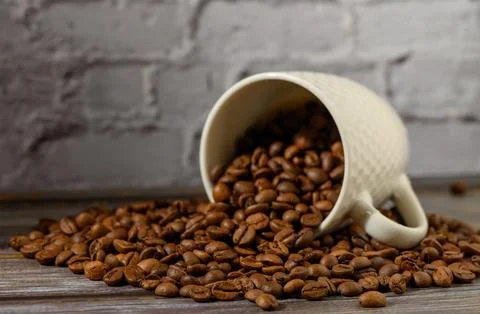 Spilled coffee beans create a captivating scene in a rustic kitchen setting Photos