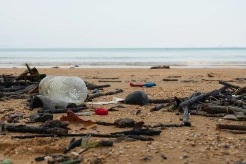 Spilled garbage on the beach. Empty used dirty plastic bottles. Environmental Stock Photos