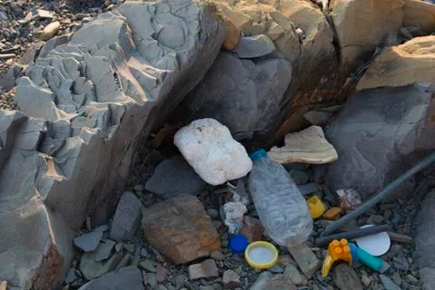 Spilled garbage on the beach. Empty used dirty plastic bottles. Dirty sea sandy Foto stock