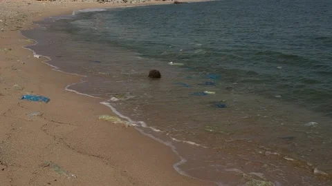 Spilled garbage on the beach near construction plant, Pollution on the beach Stock Footage 136867969