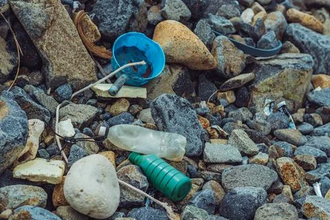 Spilled vivid multi colour garbage on stones background. Close up big plastic Foto stock