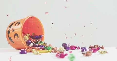 Spilling orange jack-o'-lantern bucket across white tabletop studio with foil Stock Photos