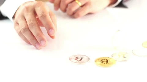Spin bitcoin on a white table with business hand in suit background. Stock Footage 87773144