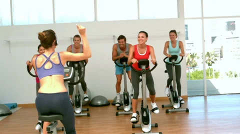 Spin class working out with instructor Video stock 35800567