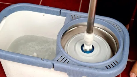 Spin Mop Head Rotating in Wringer Basket with Water Bubbles in Bucket for C.. Stock Footage 321116980