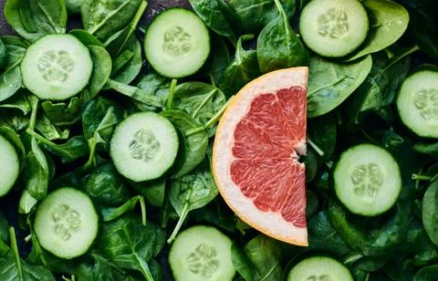 Spinach, cucumber and grapefruit on a brown background Stock Photos