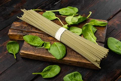 Spinach green colored pasta, on old dark wooden table background Stock Photos