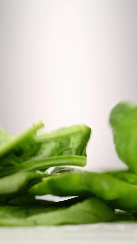 Spinach leaves cascade in slow motion. Perfect organic food visuals. 스톡 동영상 310394816