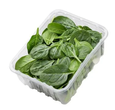 Spinach leaves in a plastic box close-up on a white background. Isolated Stock Photos