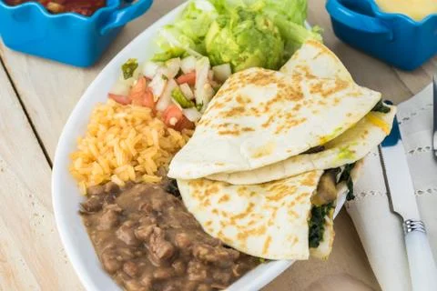 Spinach mushroom quesadillas with refried beans and rice. Stock Photos