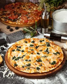 Spinach pizza covered with cheese Stock Photos