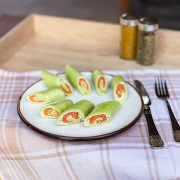 Spinach rolls filled with salmon served on a plate in a casual dining setting Stock Photos