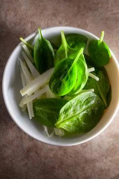 A Spinach Salad with apple on a stone surface. Stock Photos