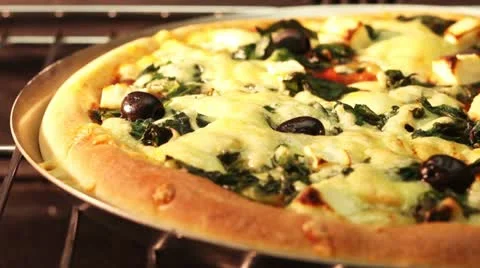 A spinach, sheep's cheese and olive pizza in an oven Stock Footage 24672228
