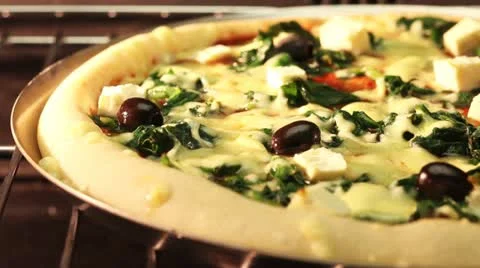 A spinach, sheep's cheese and olive pizza in an oven (time lapse) Stock Footage 24672231