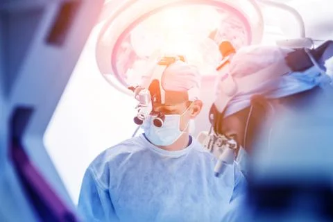 Spinal surgery. Group of surgeons in operating room with surgery equipment. Stock Photos