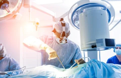 Spinal surgery. Group of surgeons in operating room with surgery equipment. Stock Photos